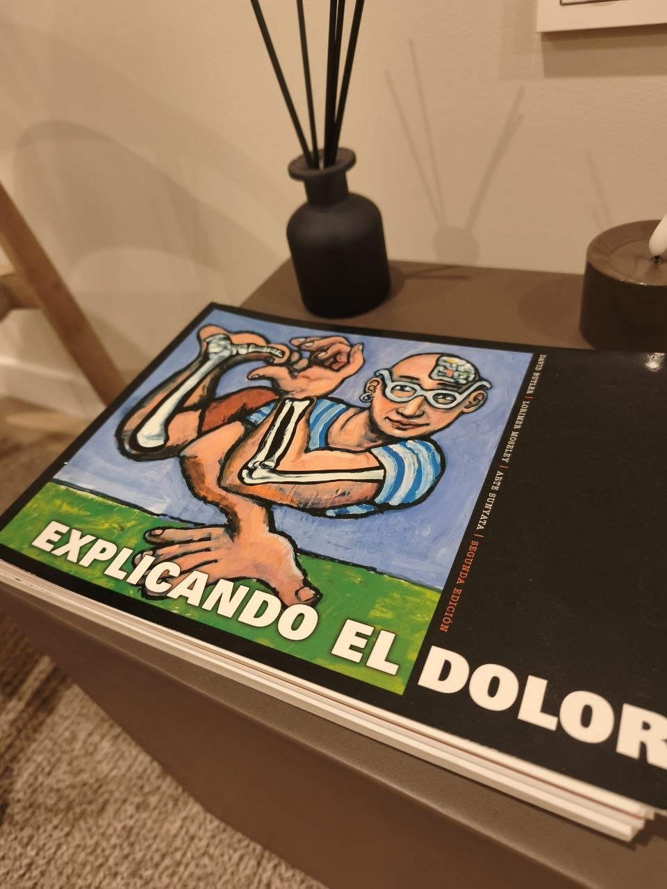 Libro Explicando el dolor sobre la mesa de la consulta de FIKIO
